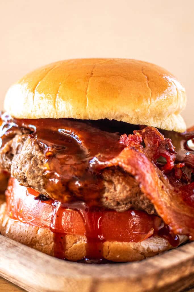 Fully dressed BBQ bacon elk burger on a bun.