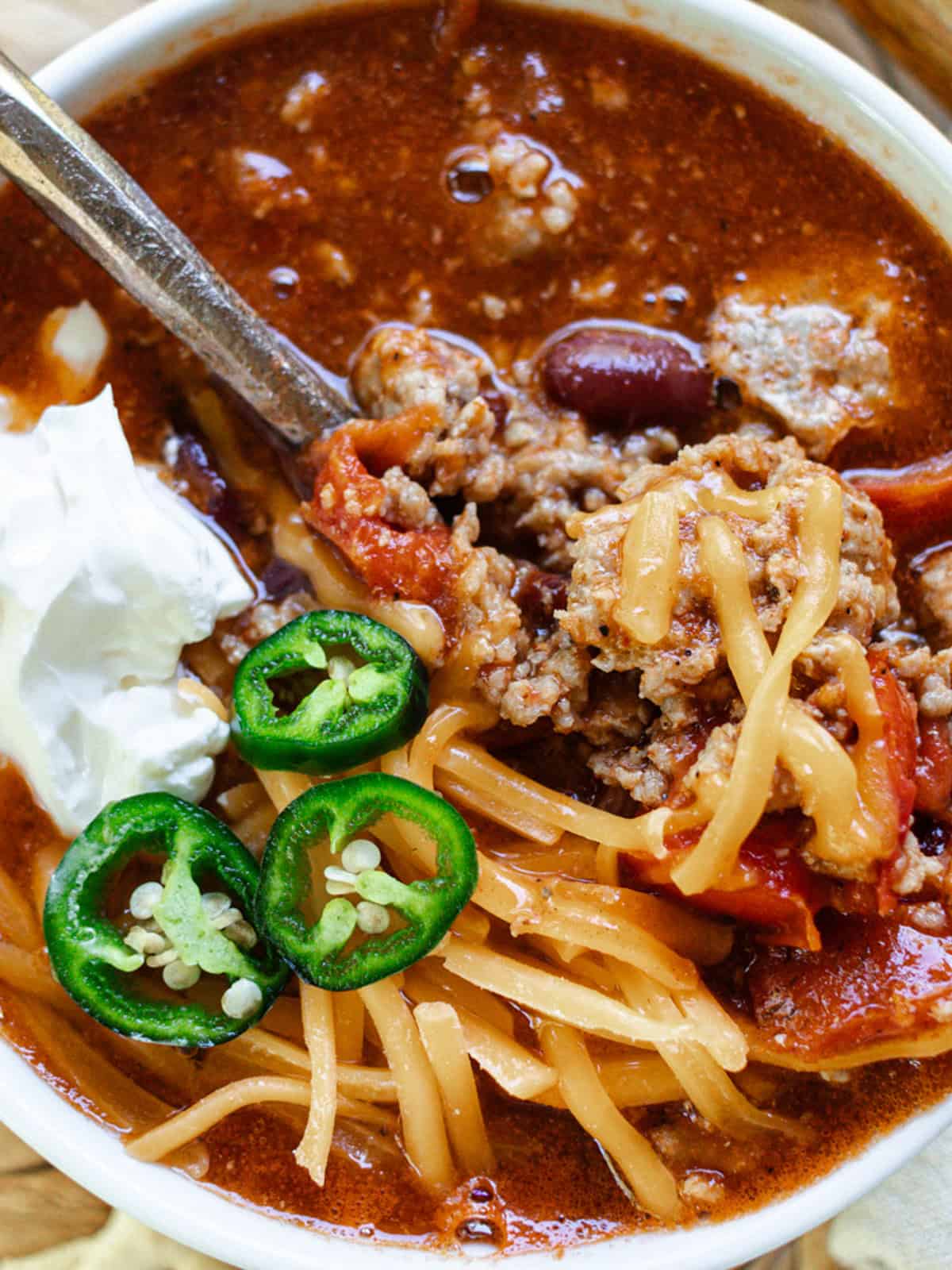 Ground Pork Chili with jalapeno and cheese on top.