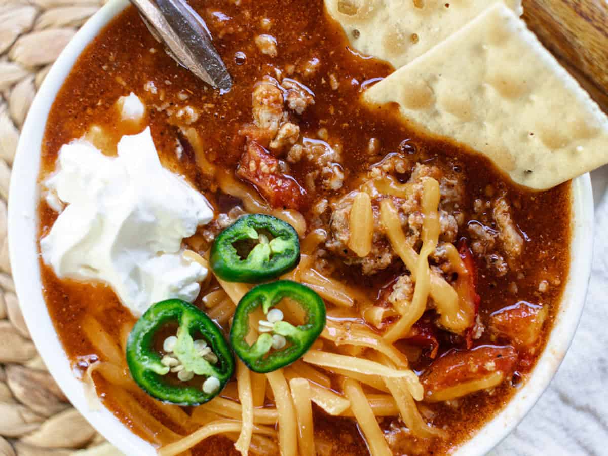 Ground Pork Chili served with crackers and sour cream on top.