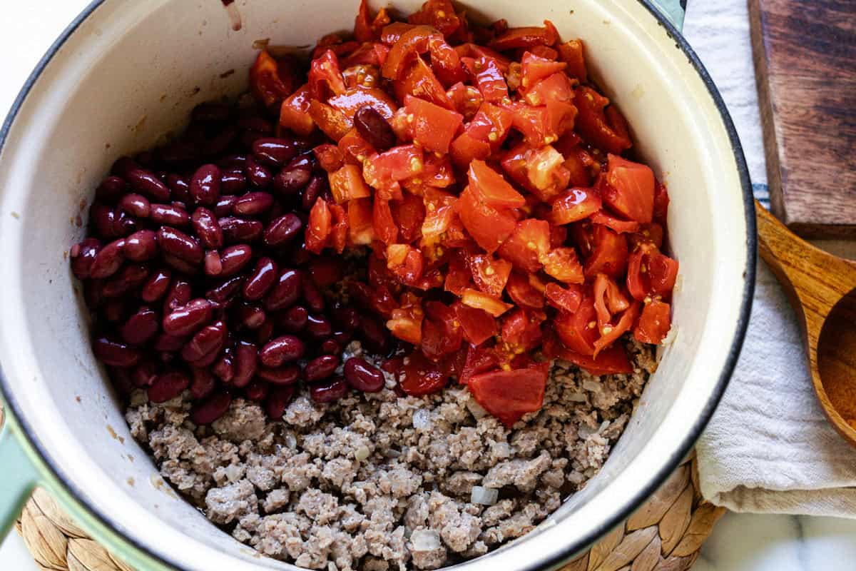 Ground pork, onion, tomatoes, and beans in a dutch oven.
