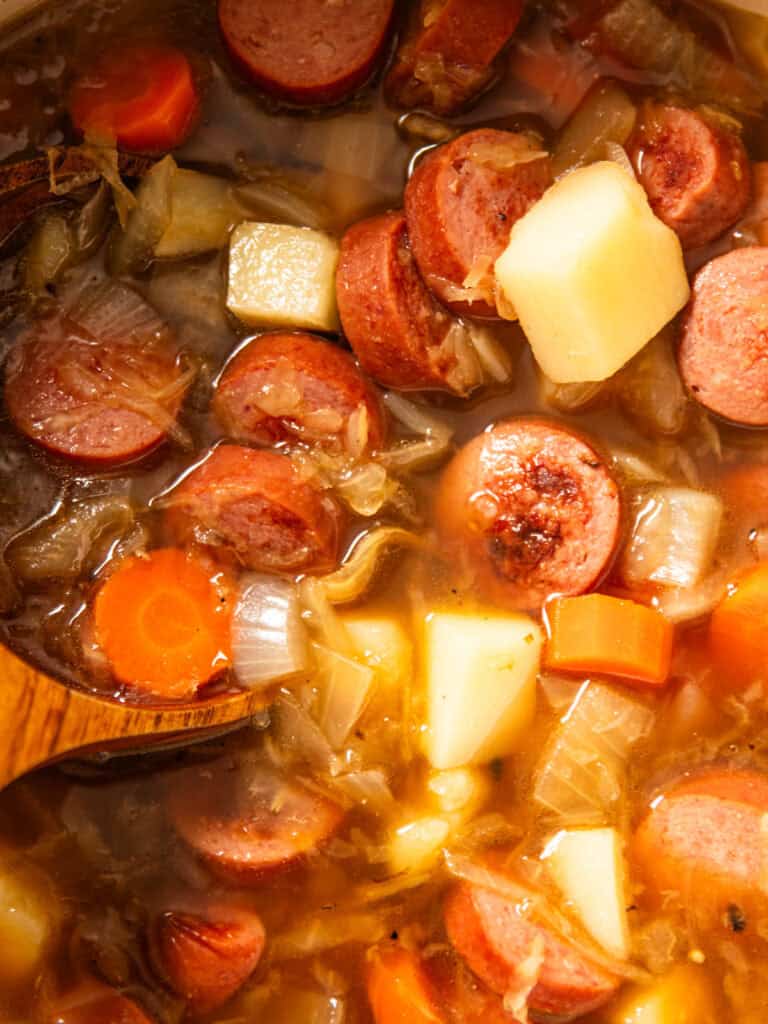 Polish Sauerkraut Soup with a wooden serving spoon.