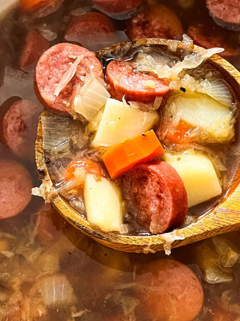 A wooden spoon full of Polish Sauerkraut Soup.
