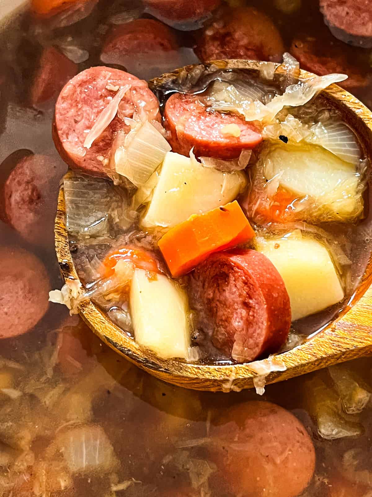 A wooden spoon full of Polish Sauerkraut Soup.