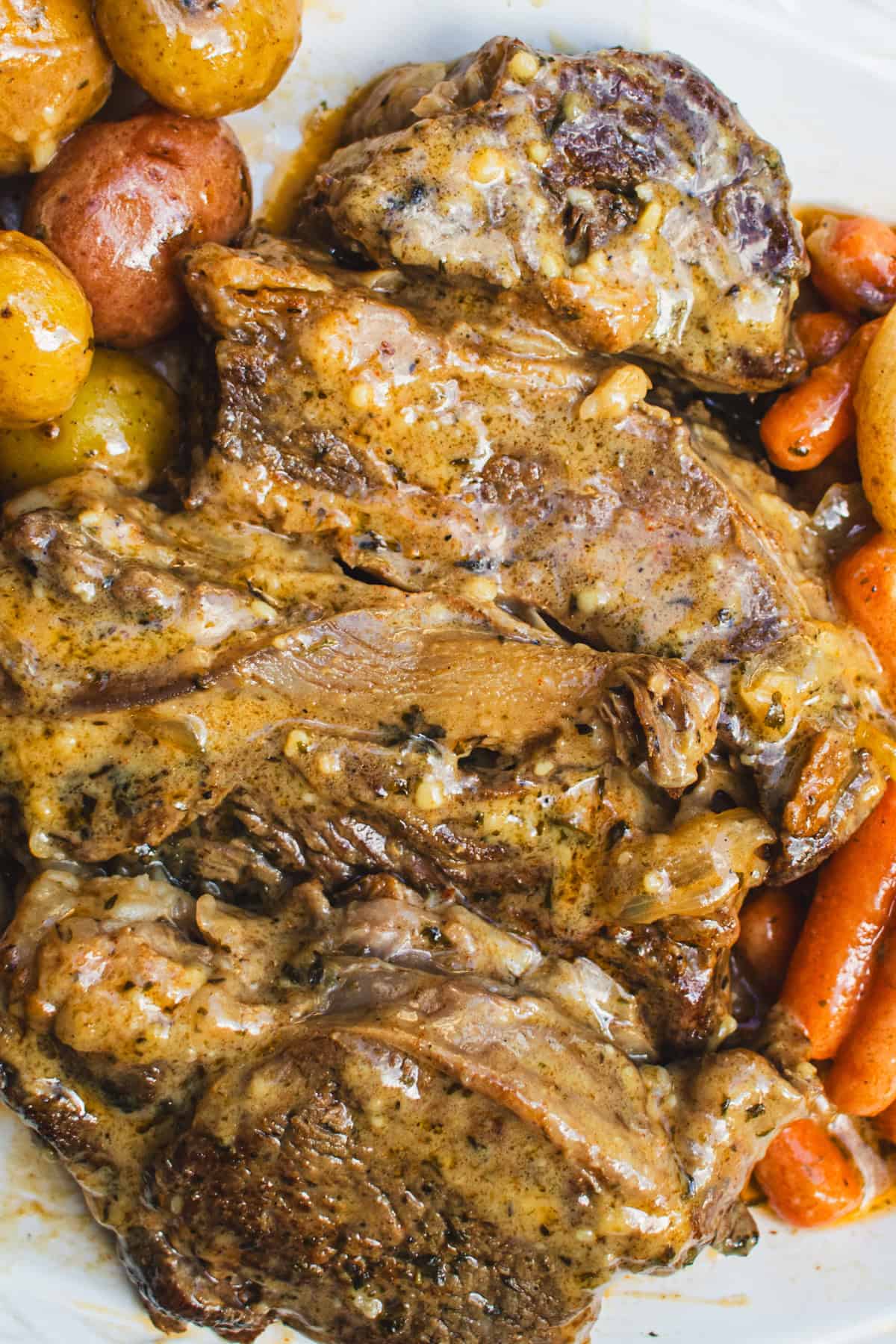 Sliced dutch oven pot roast drizzled with a brown gravy.