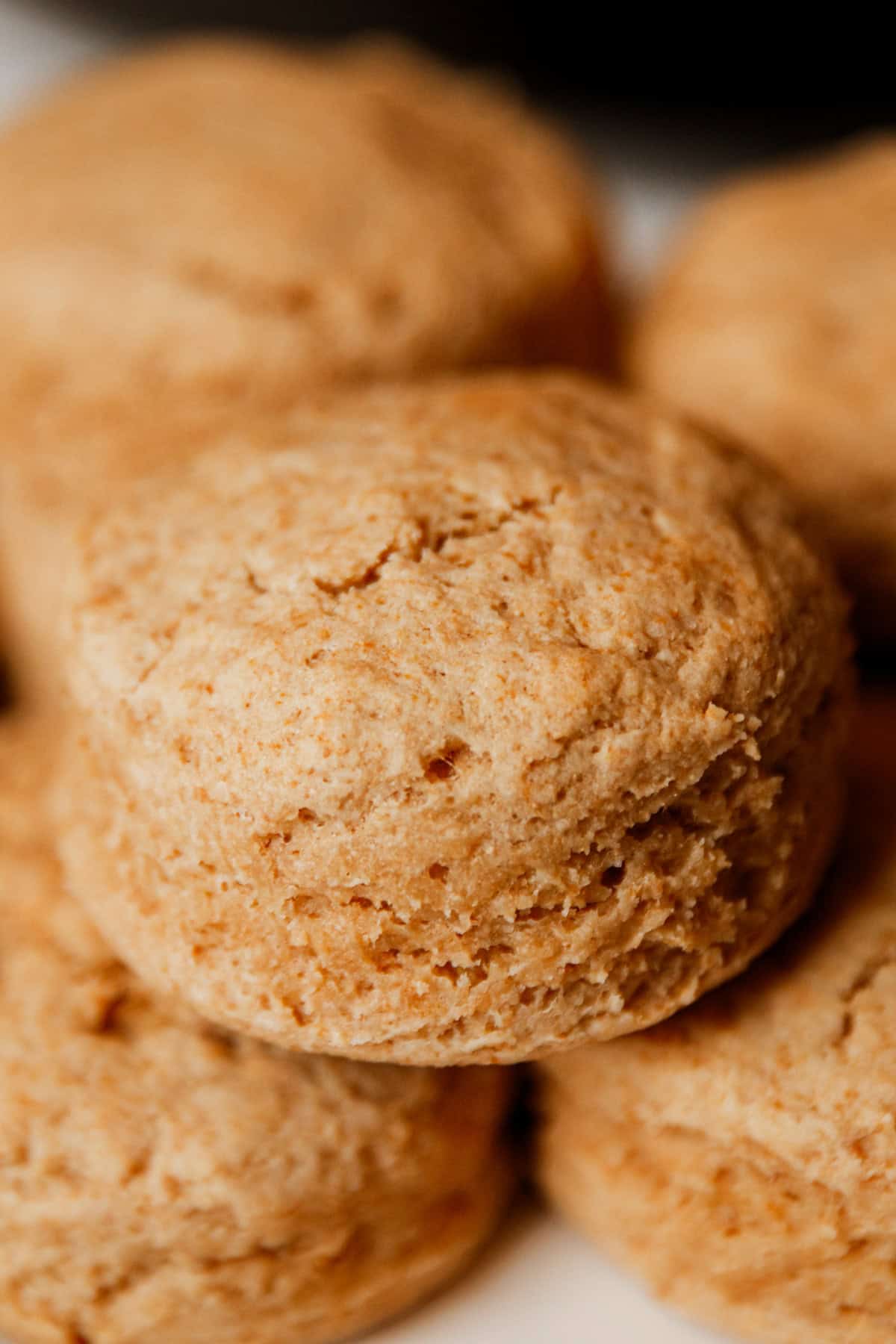 Whole grain biscuits stacked on a white plate.