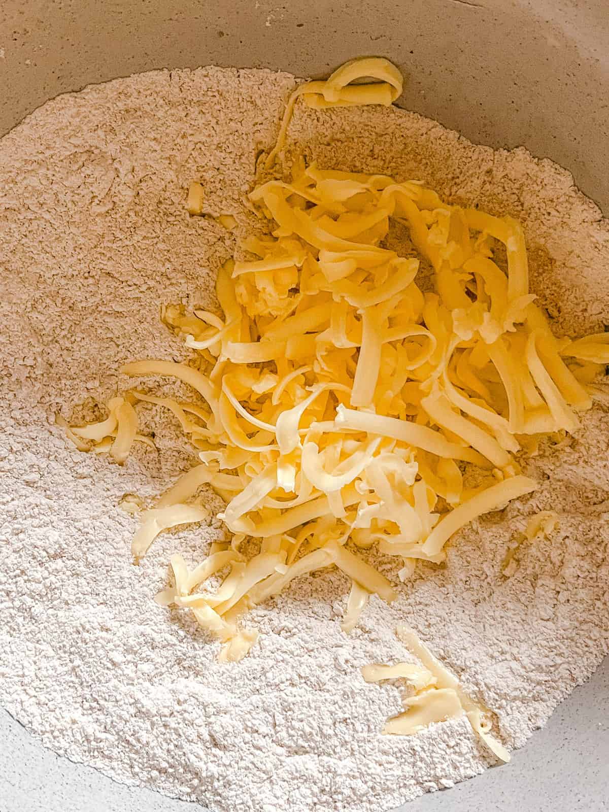 Shaved butter in a bowl of flour.