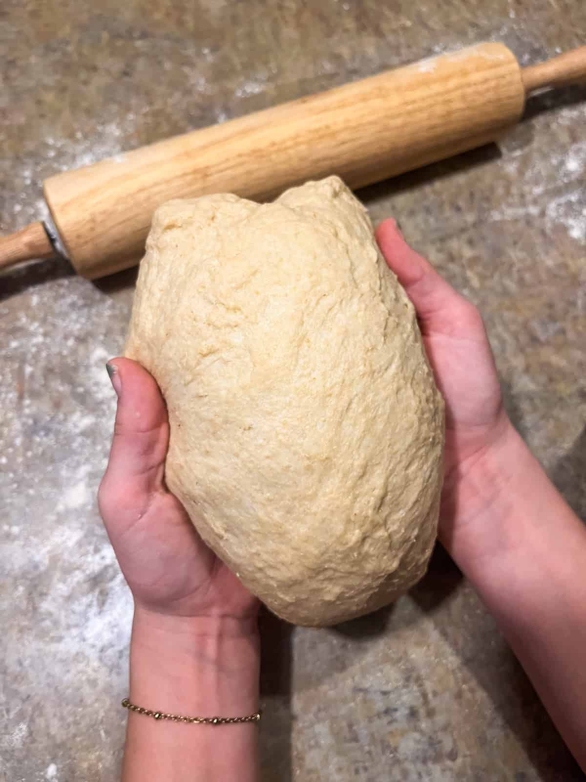 Shaping the dough after the first rise into a loaf. 