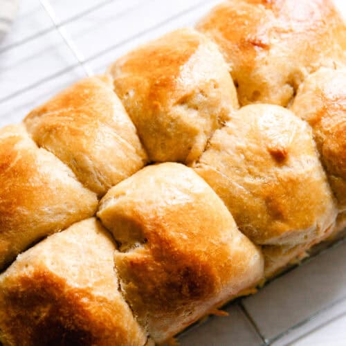 A loaf of whole grain brioche bread on a striped towel.