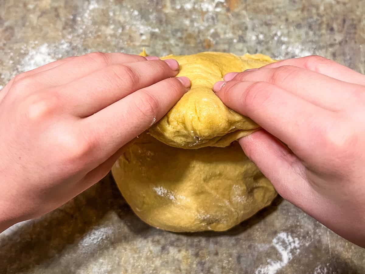 Folding the brioche dough over on a countertop.