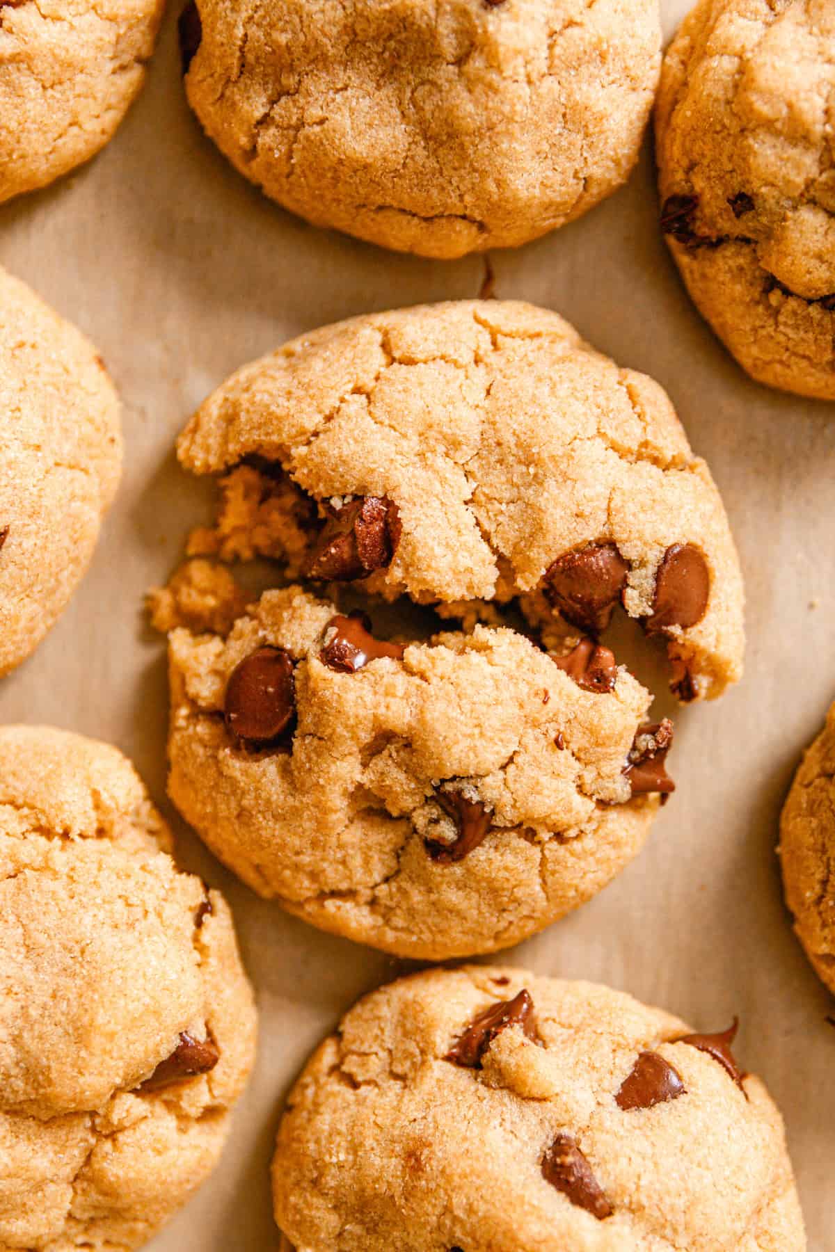 A whole grain chocolate chip cookie broken in half.