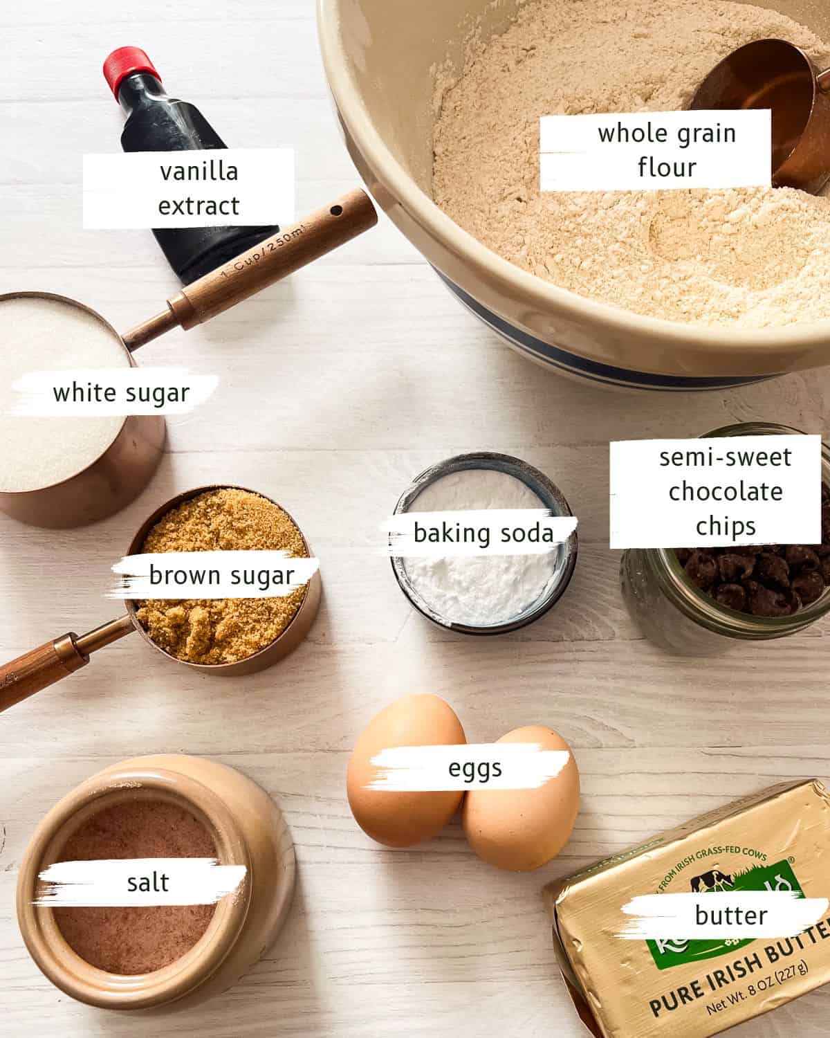 Whole grain chocolate chip cookie ingredients assembled on a white table.