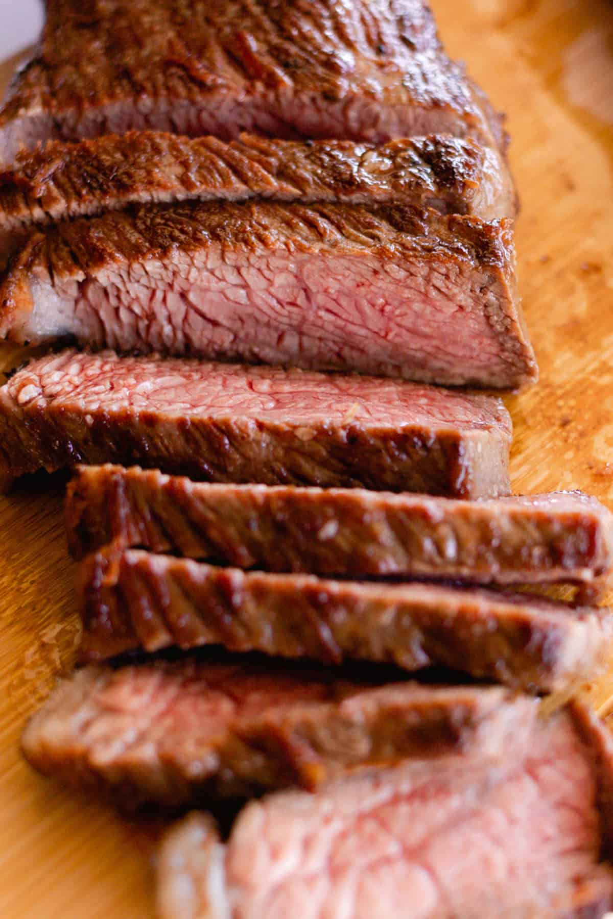 Sliced Picanha Steak laid out on a wood cutting board.