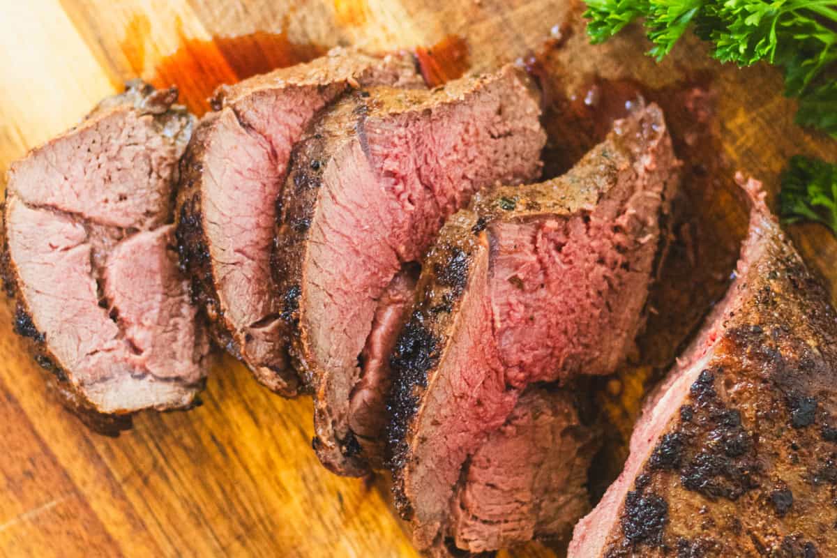 Venison Backstrap sliced on a cutting board.