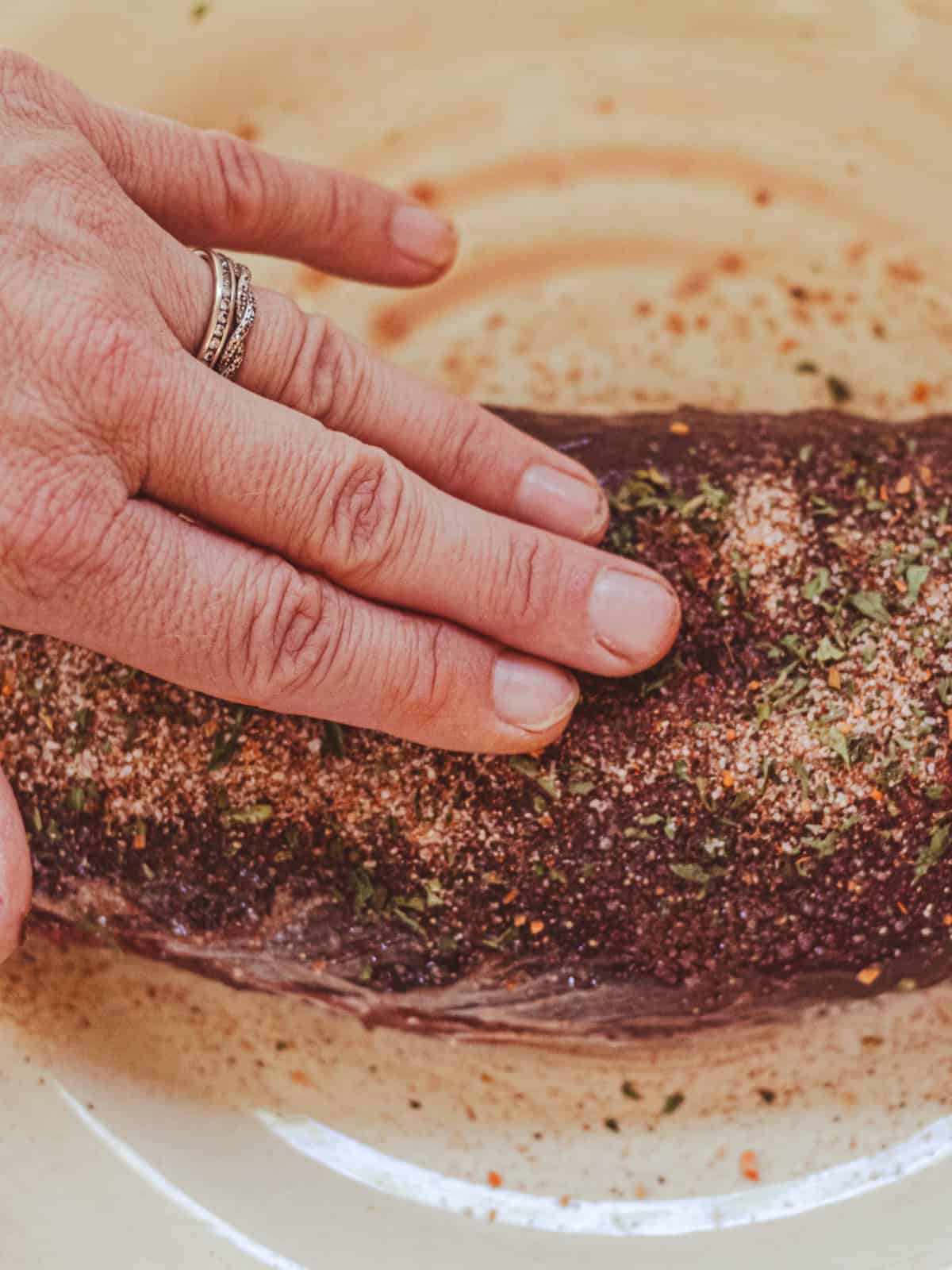 Rubbing a Venison Backstrap with a seasoning blend.