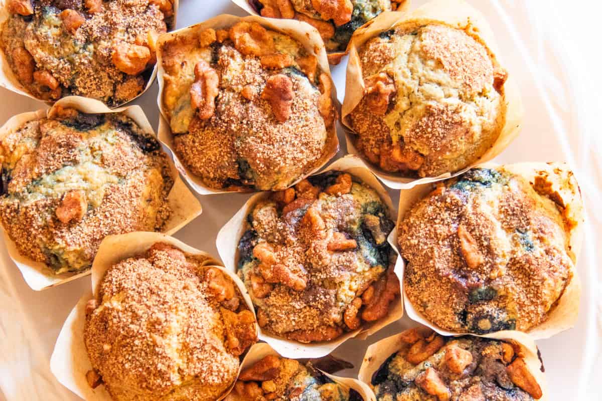 Looking down on whole grain blueberry muffins on a white plate. 