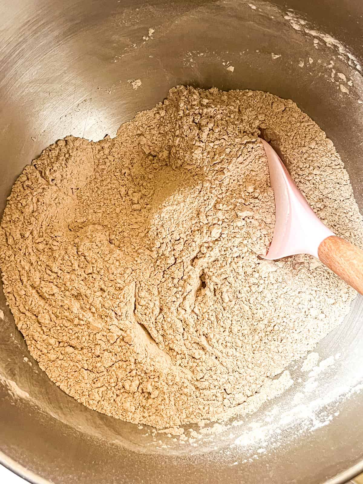 Stirring together dry ingredients in a metal bowl.
