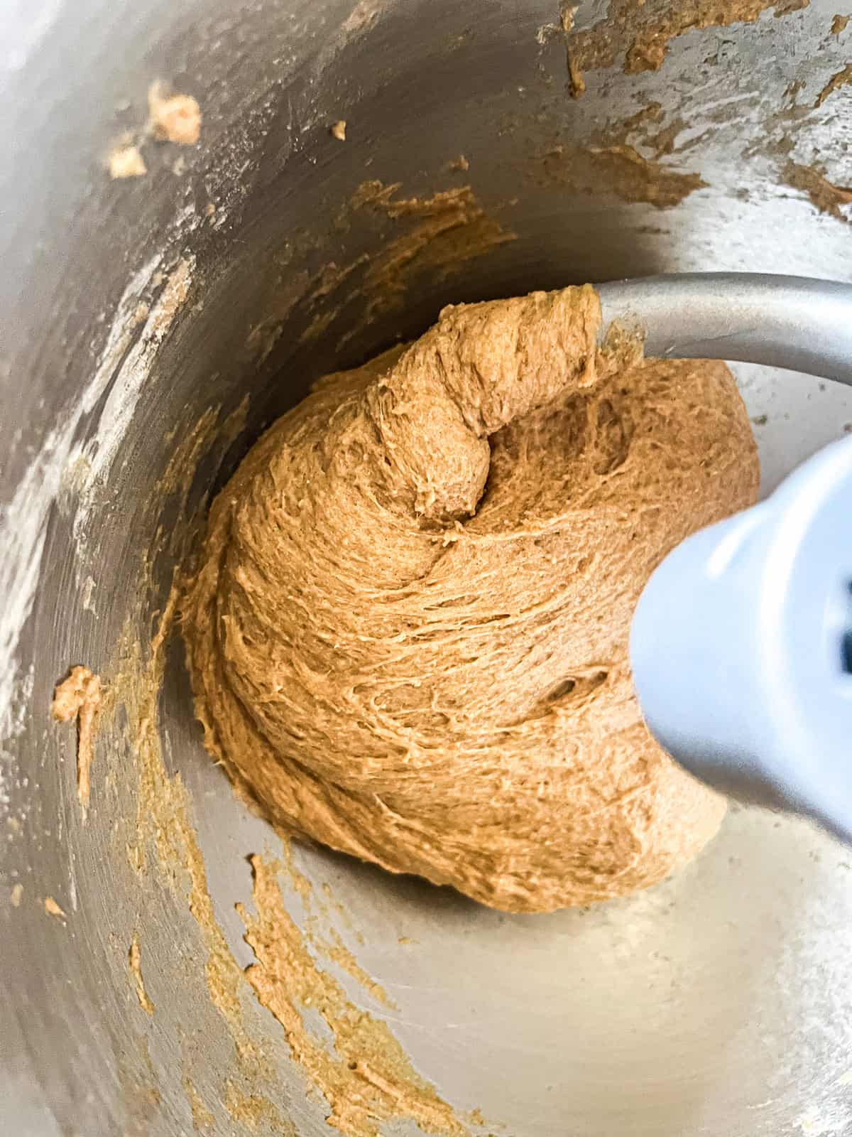 Kneading whole grain bun dough in a mixer with a dough hook.