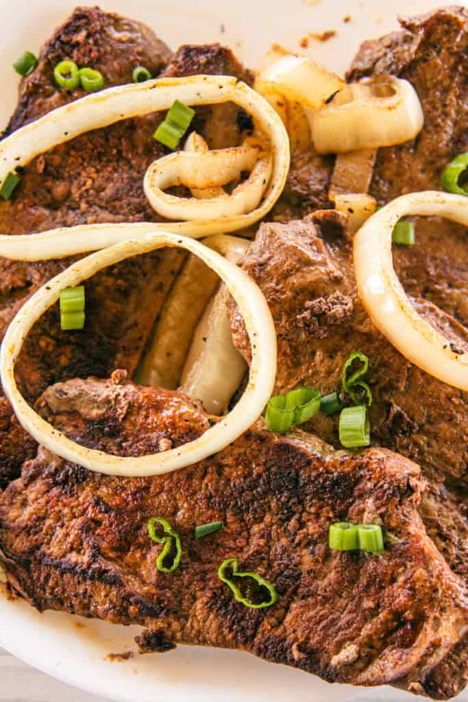 Cooked beef liver with onion slices on top.