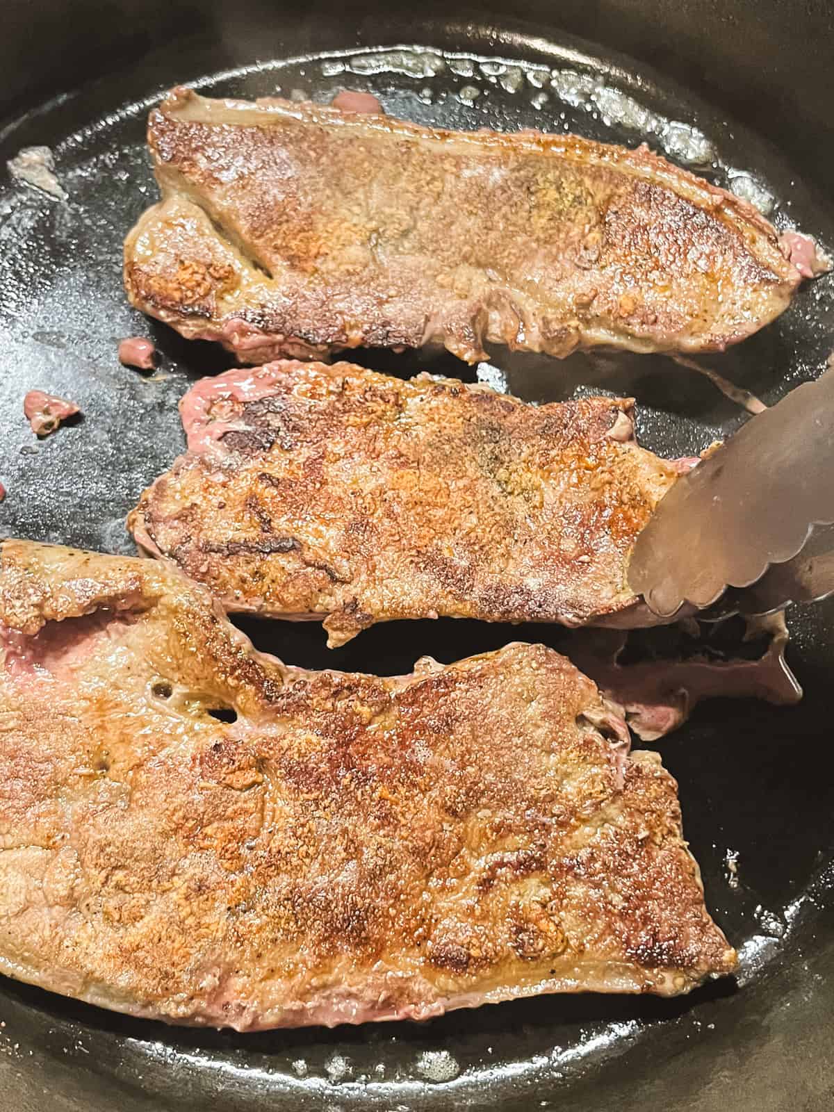 Frying beef liver in a cast iron skillet.