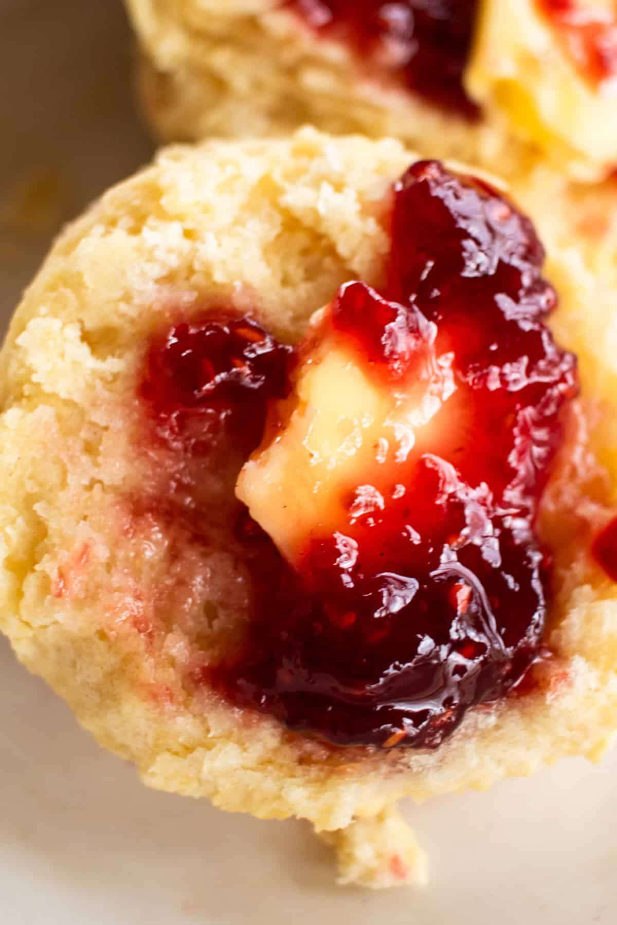 Half of a cast iron biscuit covered in butter and jelly.