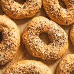 Whole grain bagels assembled on a piece of brown parchment paper.