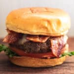 A beef brisket burger sitting on a wooden table.