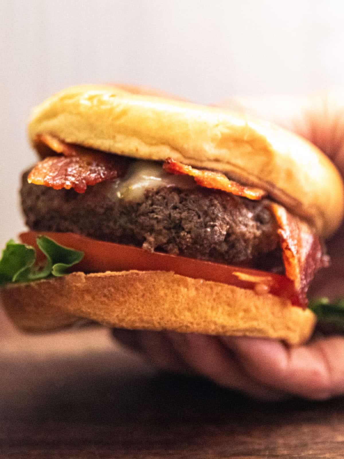 A hand holding a hamburger.