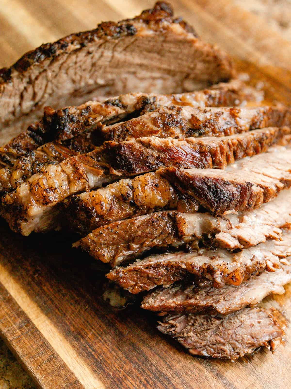 Sliced brisket on a wooden cutting board.
