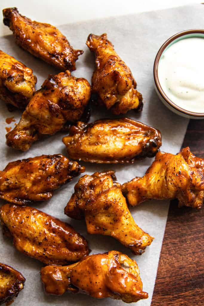 Crispy baked chicken wings on a plate with a cup of ranch.
