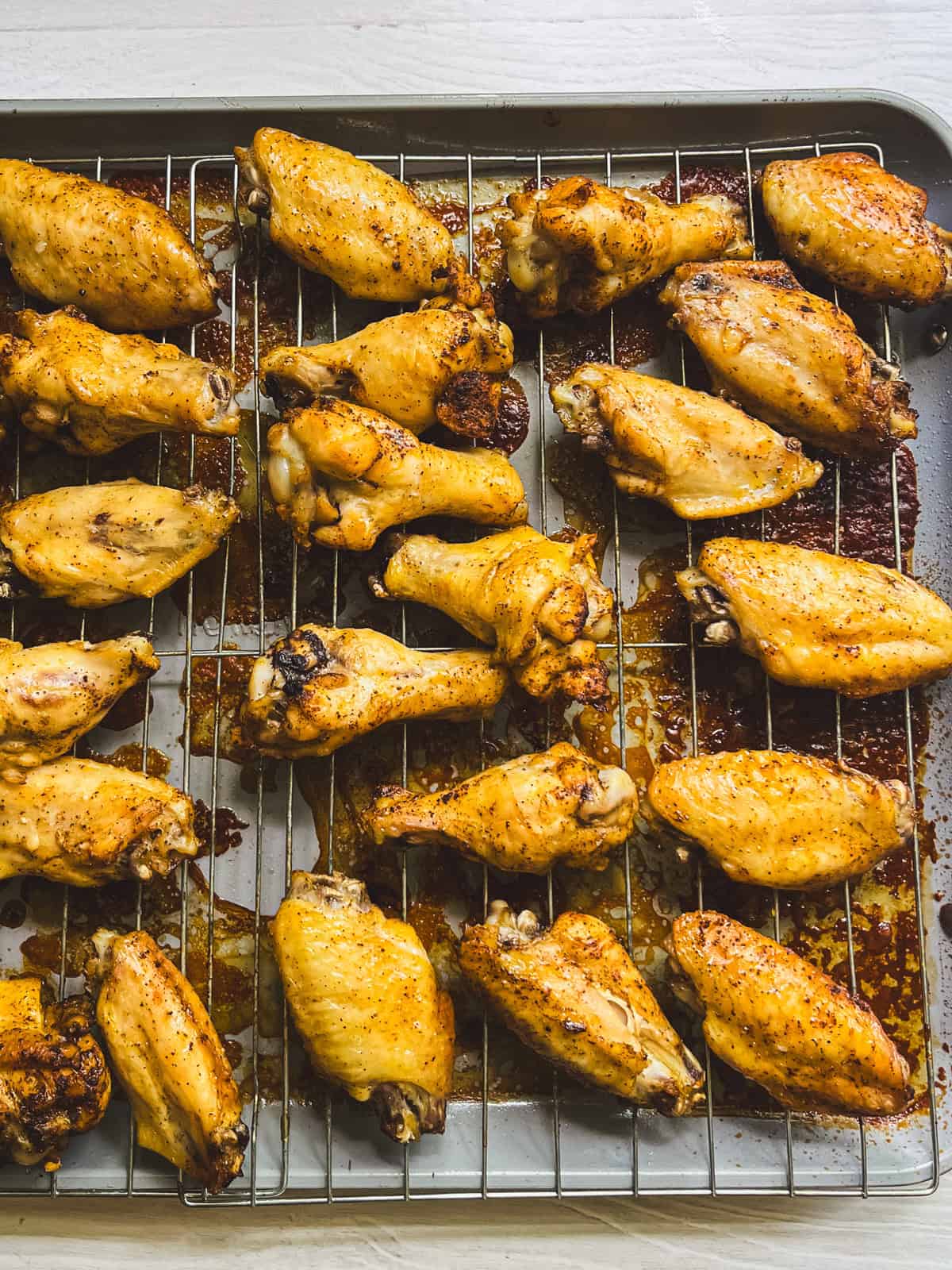 Baked chicken wings on a rack.