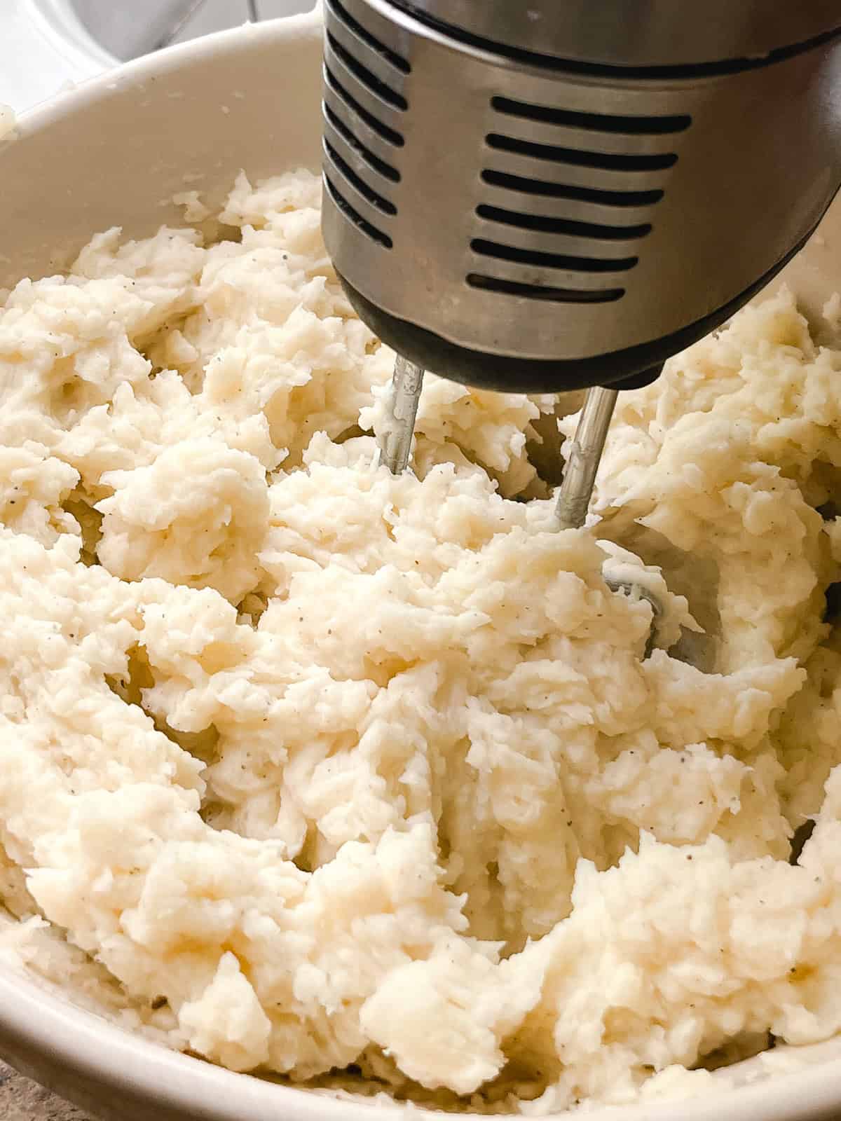 Mixing mashed potatoes with a hand mixer. 