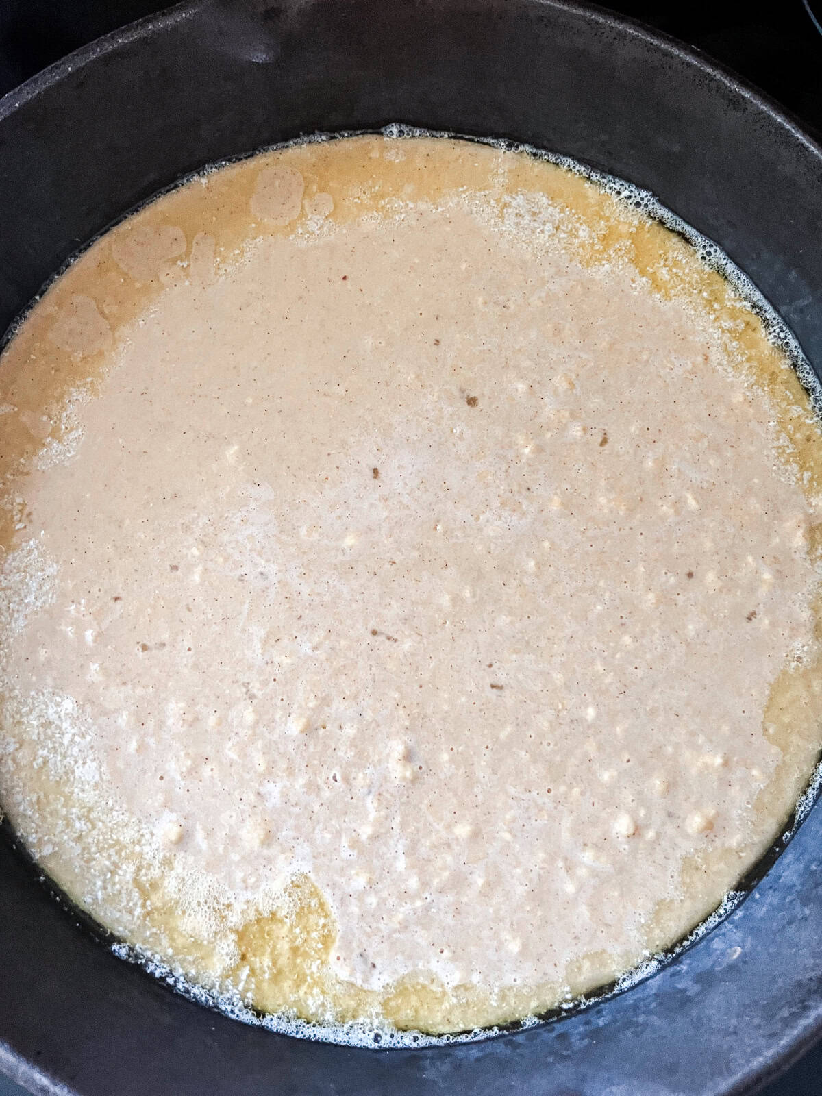 Dutch baby pancake batter in a cast iron skillet.