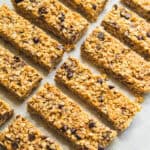 Homemade granola bars spread on a white tabletop.
