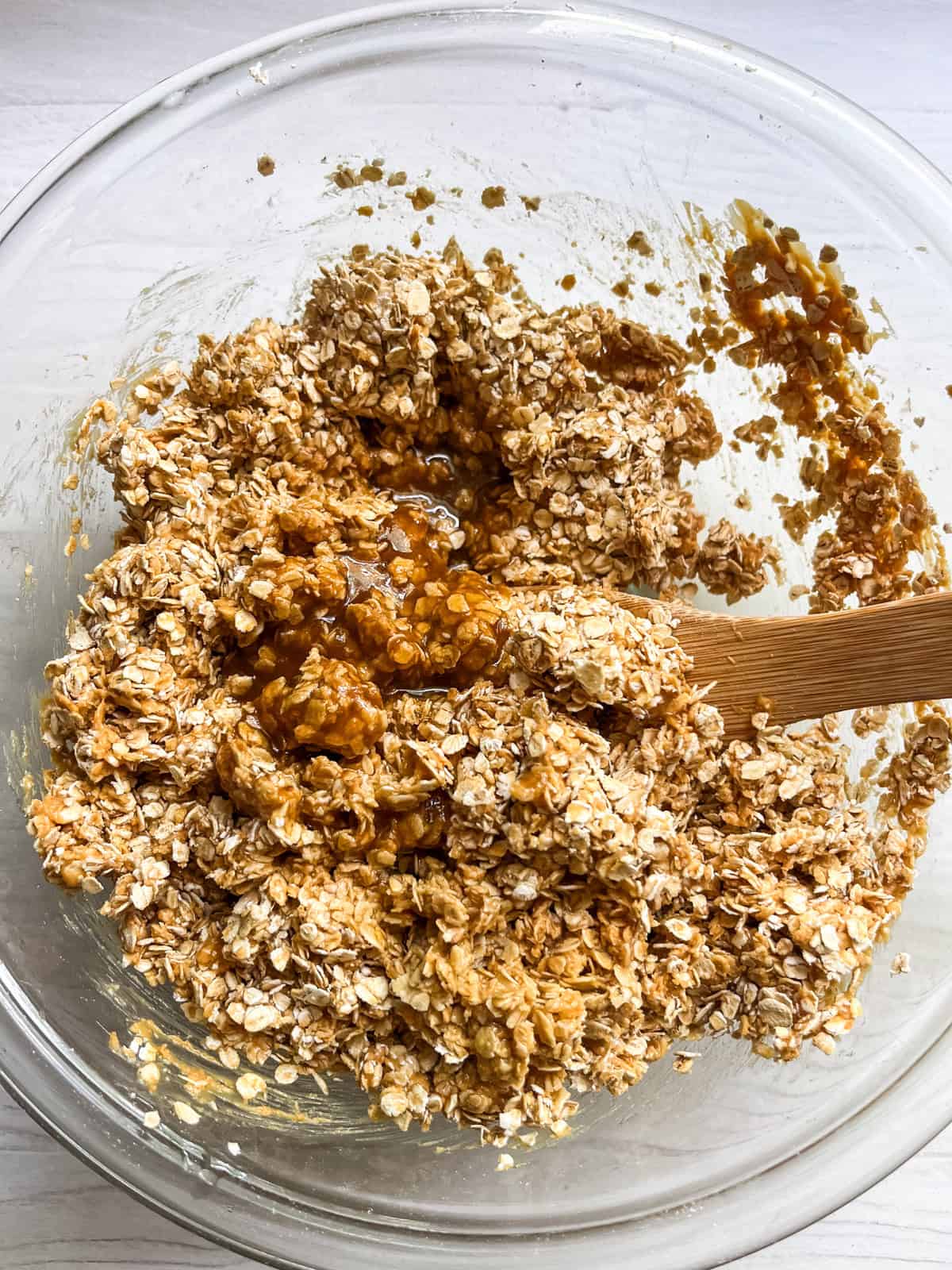 Stirring melted butter and brown sugar into homemade granola bars.