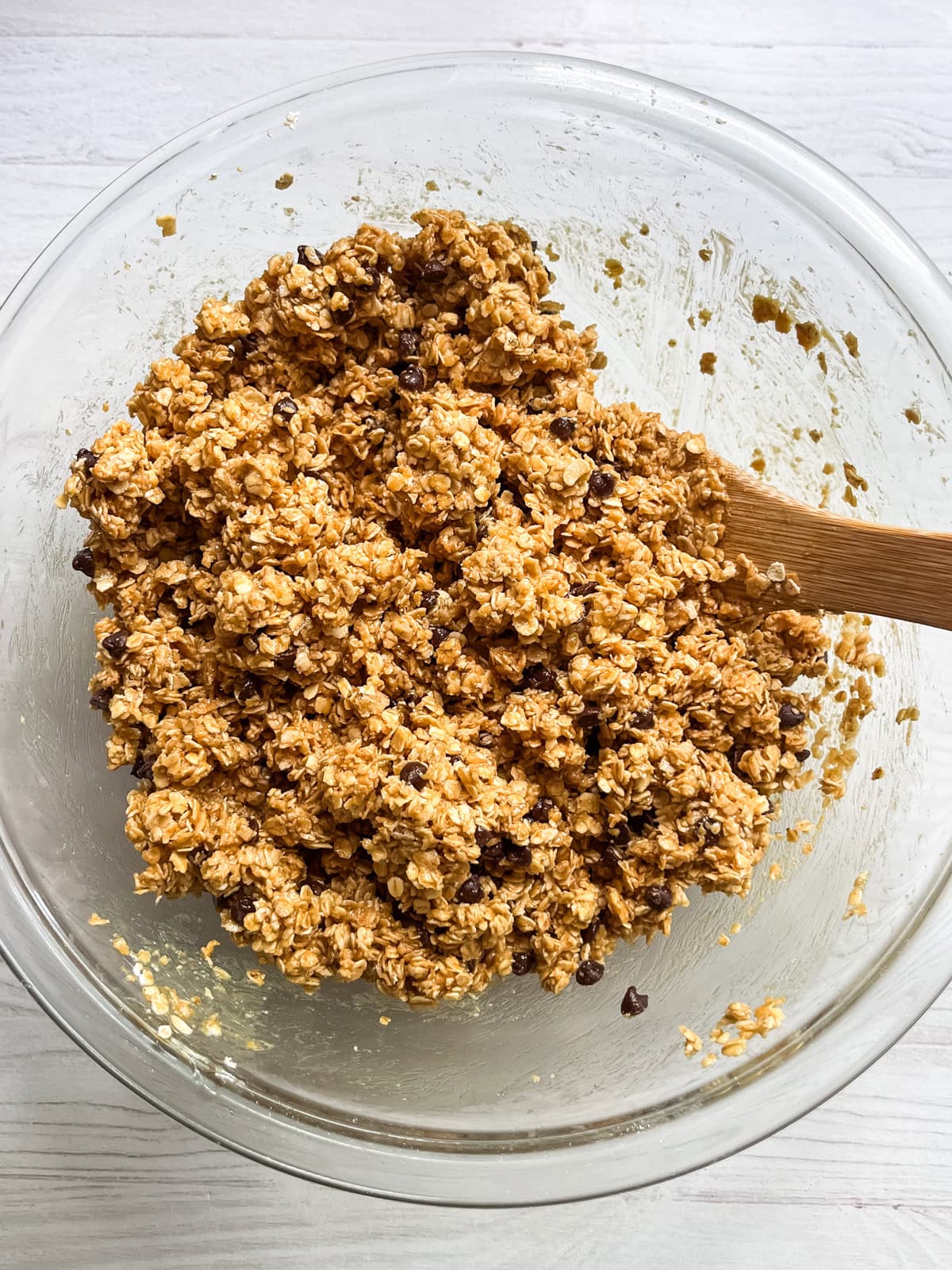 Stirring chocolate chips into homemade granola bar mixture.