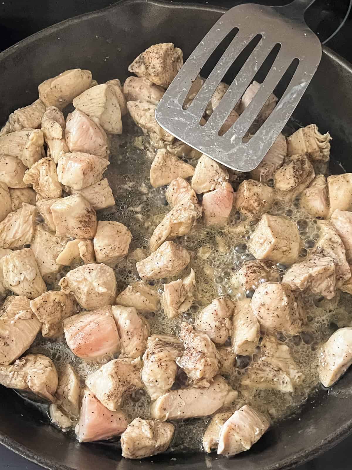 Cooking chicken in some butter in a cast iron skillet.