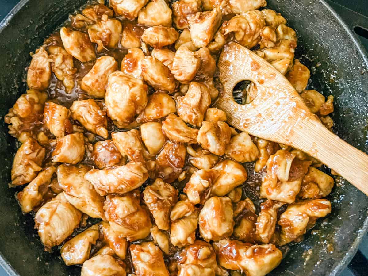 Cooking chicken pieces in garlic honey sauce.