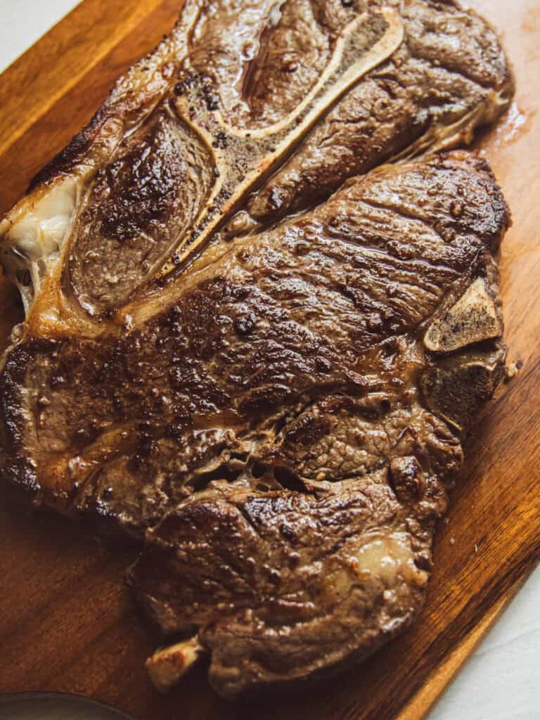 A chuck steak on a wooden cutting board.