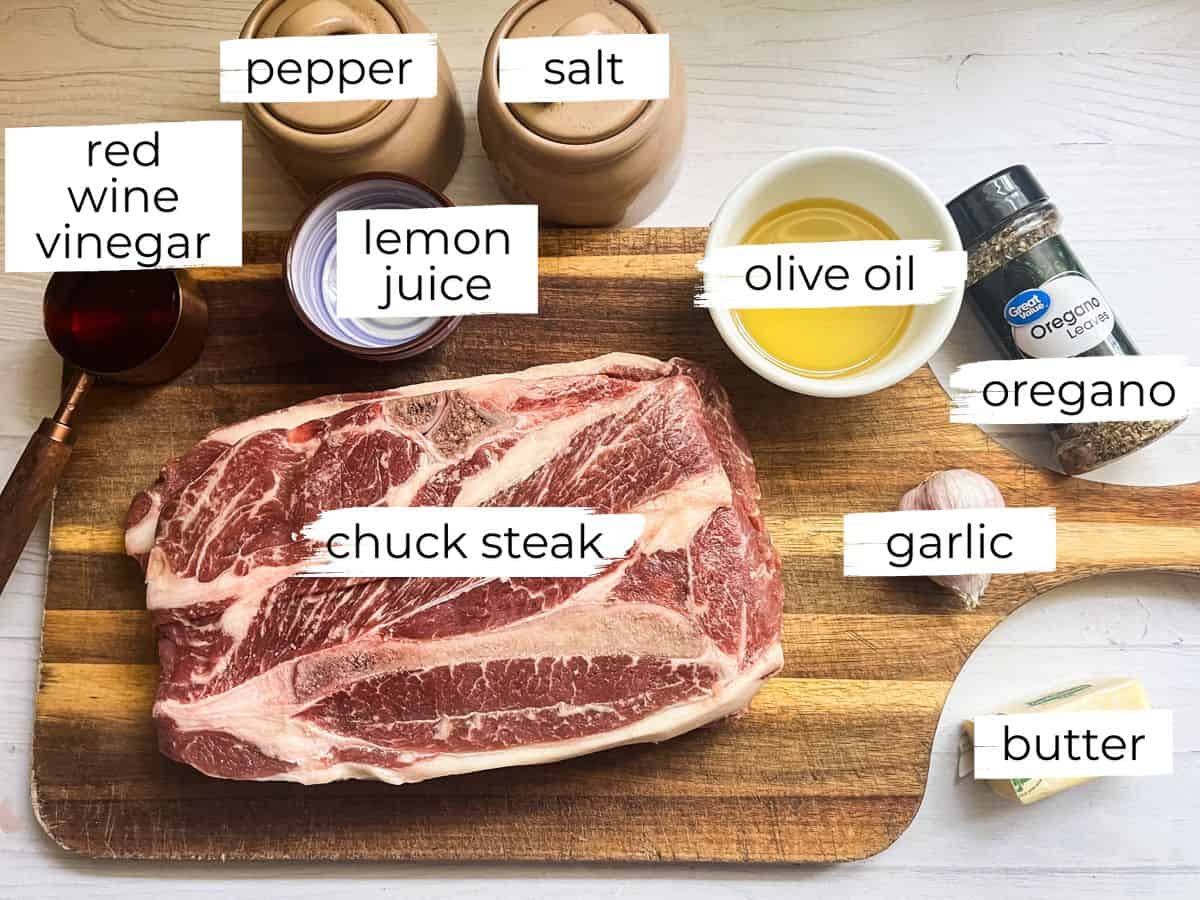Chuck steak and marinade ingredients labeled on a wooden cutting board. 