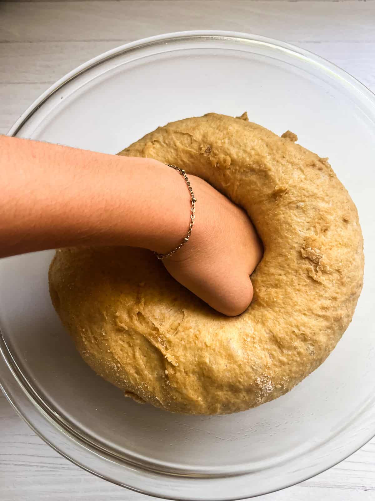 Punching down hot dog bun dough.