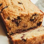 A loaf of whole wheat blueberry bread with a slice taken off the end.