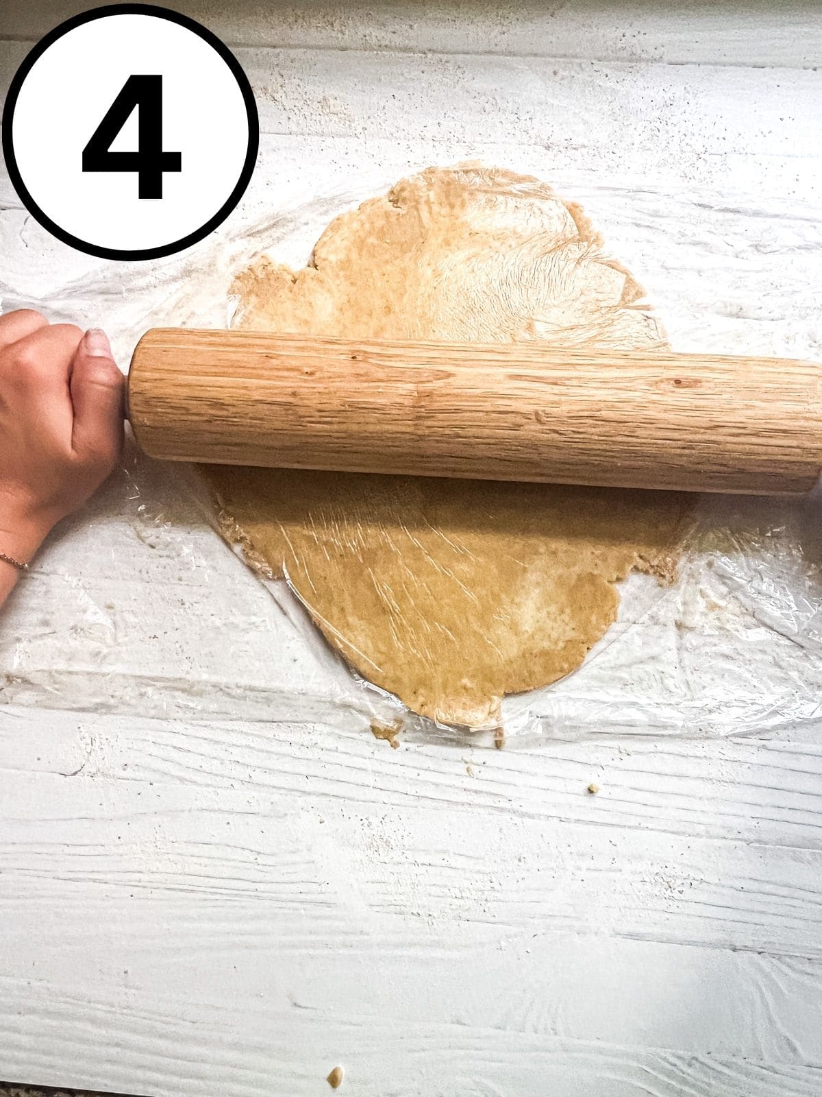 Rolling out pie dough into a flat circle with a rolling pin.
