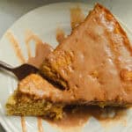 Scooping a forkful of cake out of a slice of apple cider cake.