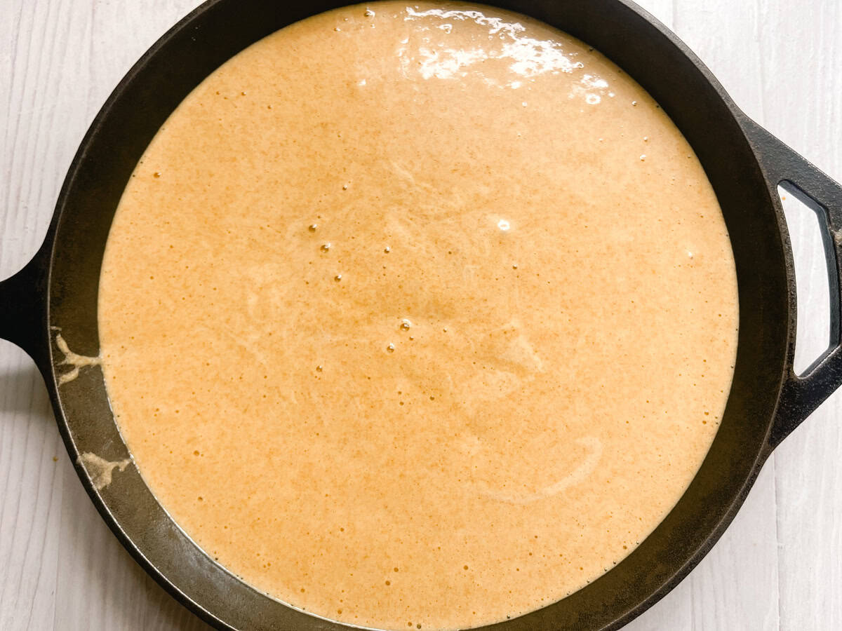 Apple cider cake in a cast iron skillet before baking.