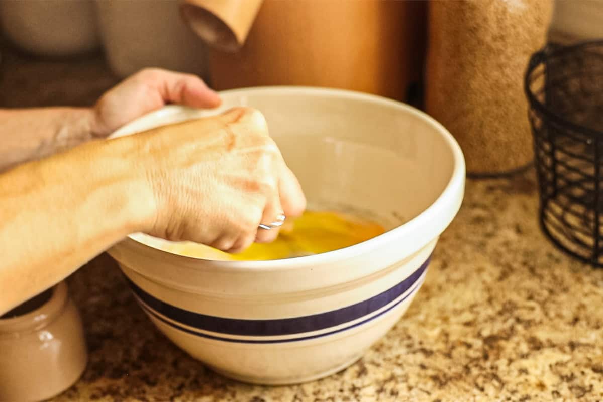 Whisking eggs in a large mixing bowl. 