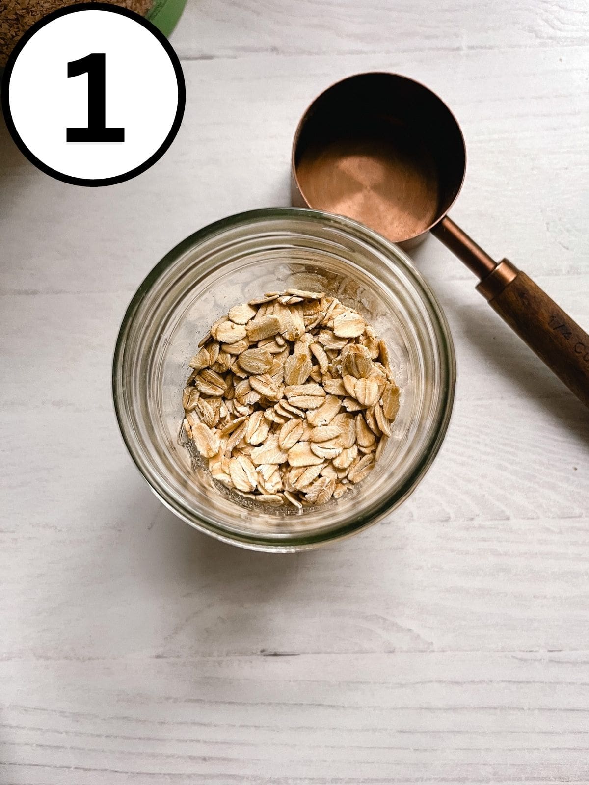 Oats in a mason jar with a measuring cup next to it.