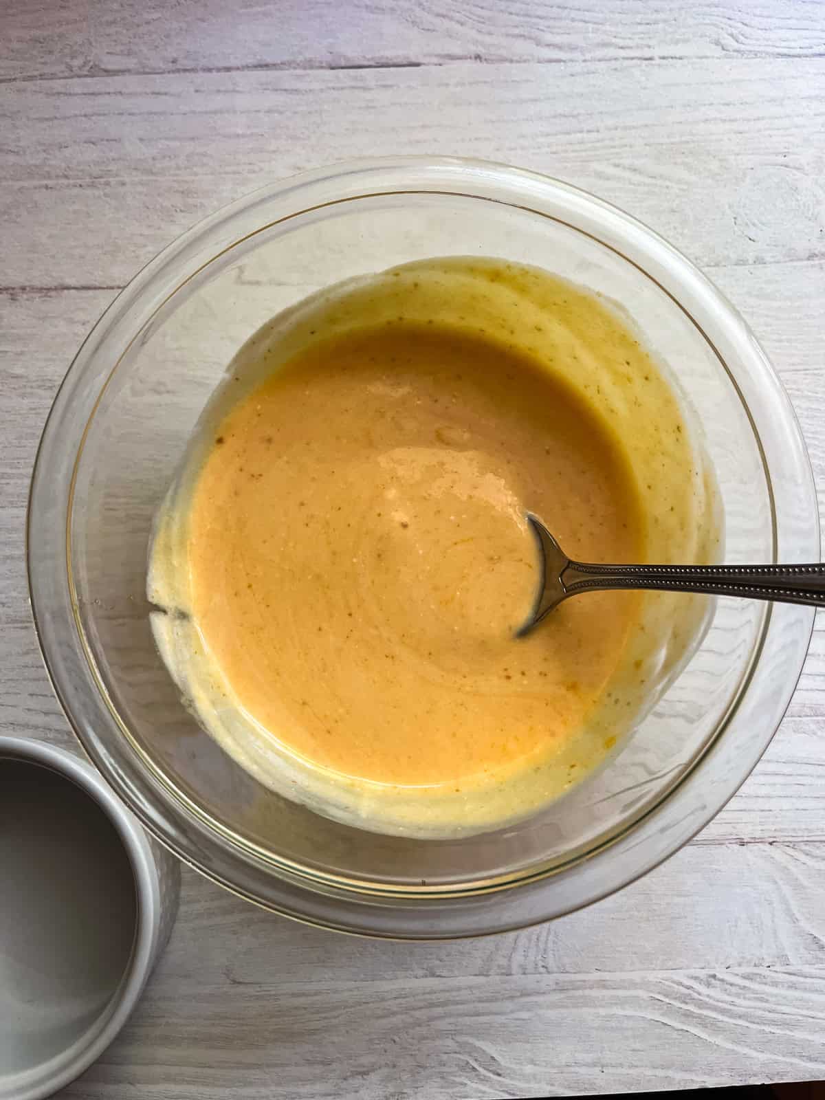 Stirring pumpkin yogurt ingredients in a small bowl.