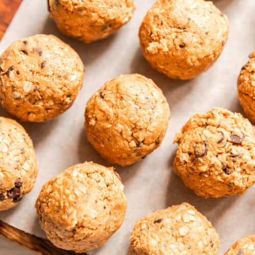 Whole grain protein balls on a parchment paper-lined baking sheet.