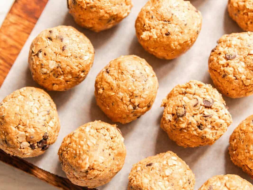Whole grain protein balls on a parchment paper-lined baking sheet.