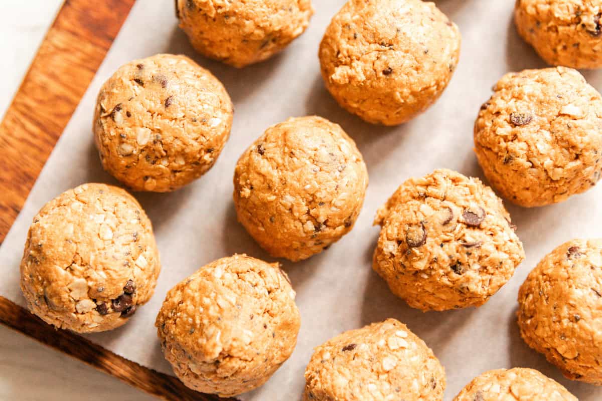 Whole grain protein balls on a parchment paper-lined baking sheet.